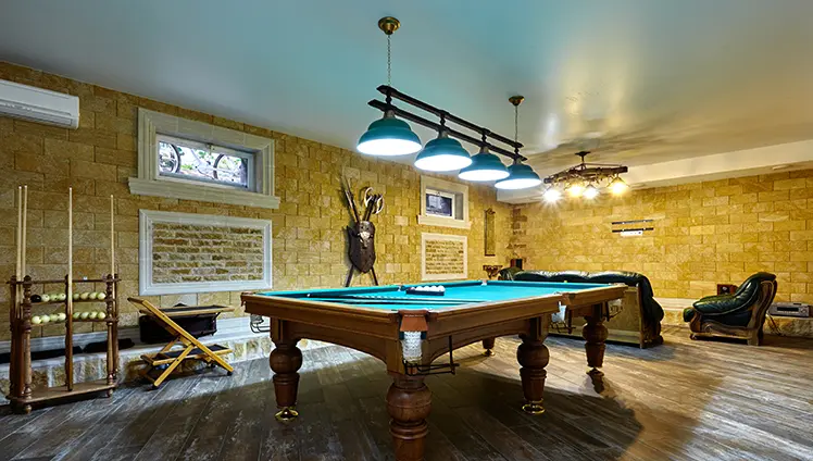 A picture of a billiards table in a basement.