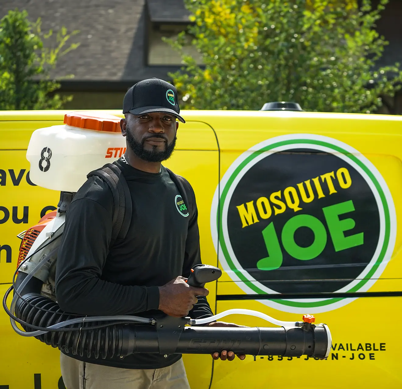 A picture of a Mosquito Joe technician standing in front of a Mosquito Joe van.