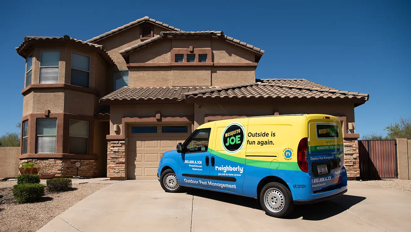 A picture of a Mosquito Joe van parked in front of a customer's home.