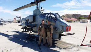 Mosquito Joe owners posing for photo next to helicopter.