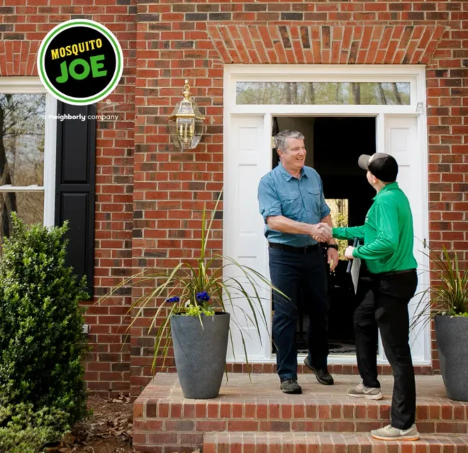 Mosquito Joe service professional shaking hands with homeowner.