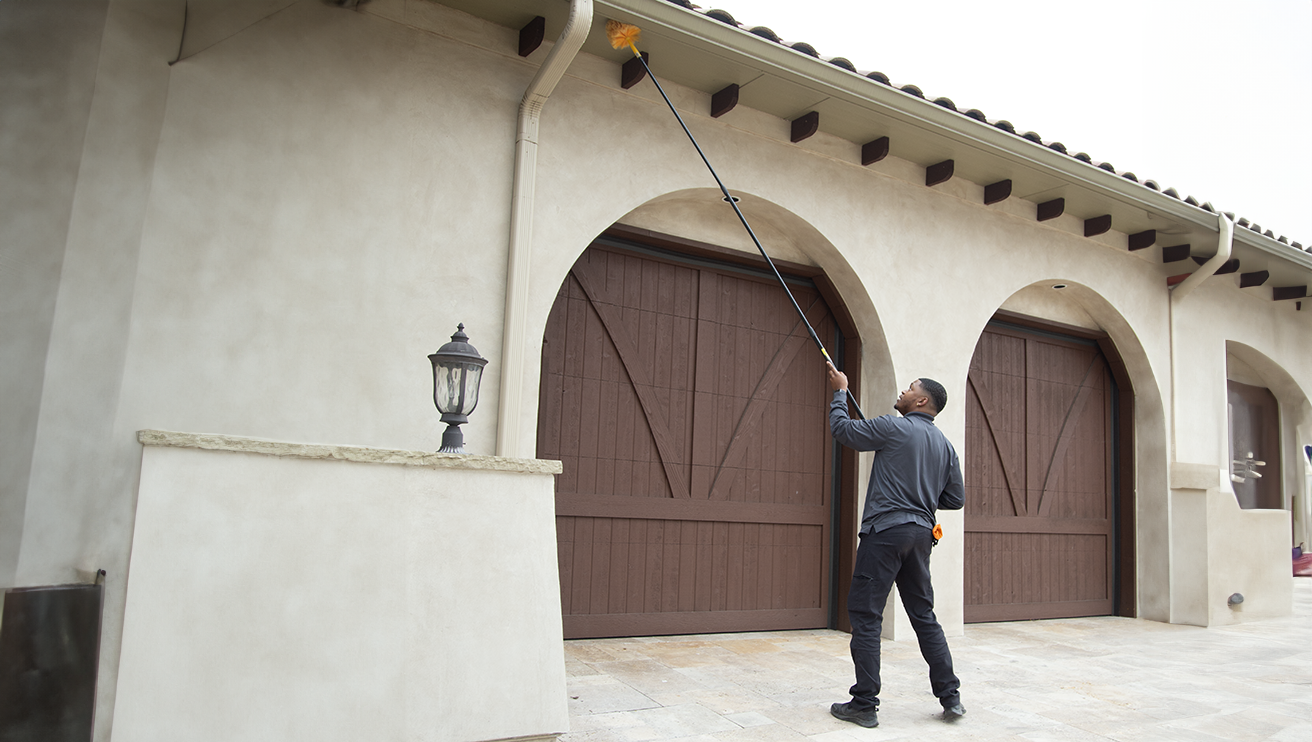 Mosquito Joe employee cleaning the roof of a building.